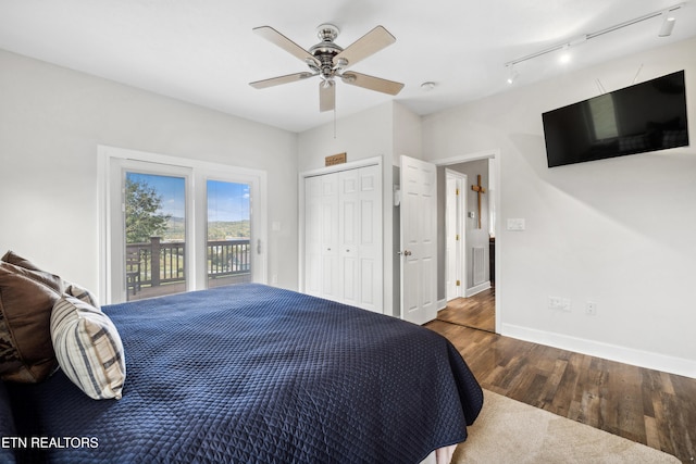 bedroom with access to exterior, dark hardwood / wood-style flooring, ceiling fan, and a closet