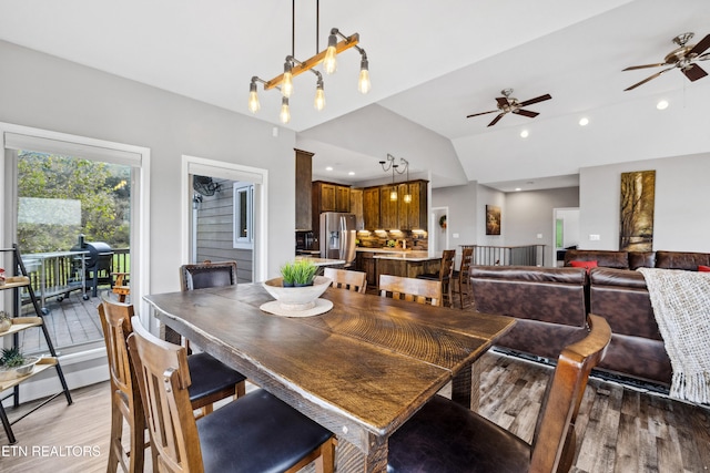 dining area with vaulted ceiling, hardwood / wood-style flooring, and ceiling fan