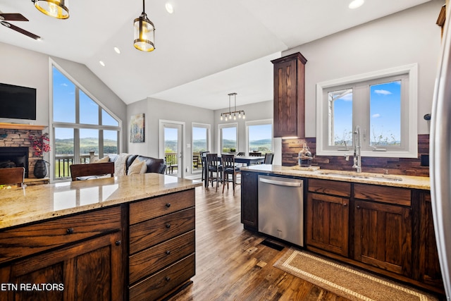 kitchen with sink, decorative backsplash, dishwasher, pendant lighting, and vaulted ceiling