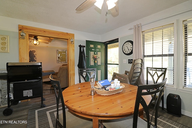 dining area with ceiling fan, a textured ceiling, and dark hardwood / wood-style floors