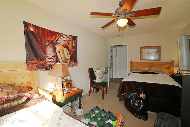 bedroom featuring a textured ceiling, light colored carpet, and ceiling fan