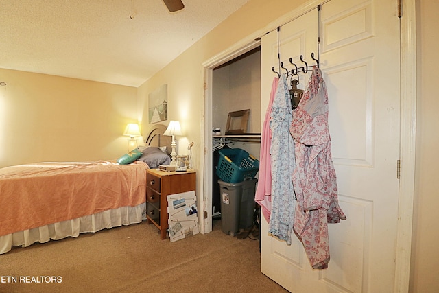 bedroom with ceiling fan, a textured ceiling, carpet flooring, and a closet