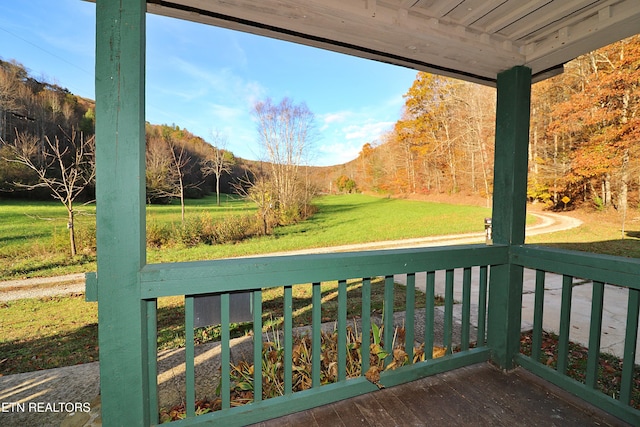 wooden deck featuring a lawn