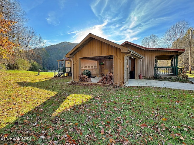 view of side of home featuring a porch and a yard