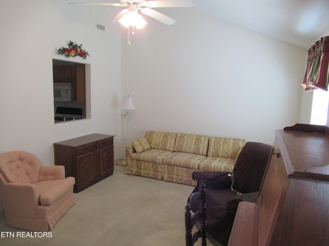 living room featuring light carpet, ceiling fan, and vaulted ceiling