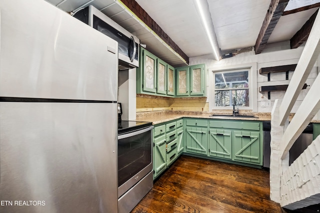 kitchen with appliances with stainless steel finishes, green cabinets, dark hardwood / wood-style floors, beam ceiling, and sink