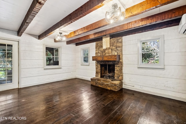 unfurnished living room featuring a fireplace, wood-type flooring, wood walls, and beam ceiling