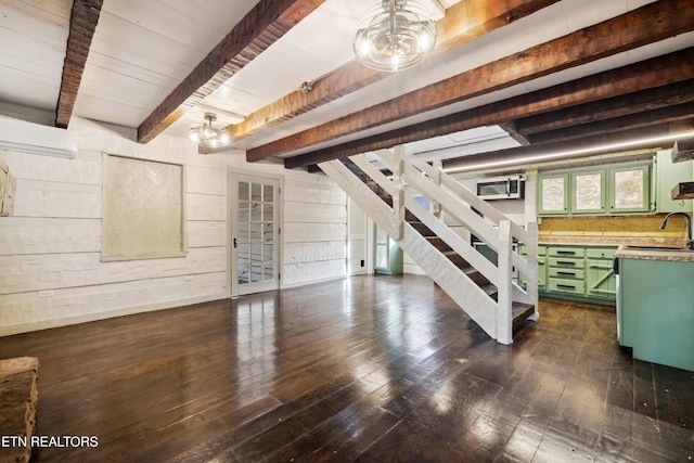 basement featuring dark hardwood / wood-style flooring, wood walls, and sink