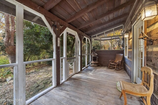 unfurnished sunroom featuring lofted ceiling with beams, plenty of natural light, and wood ceiling