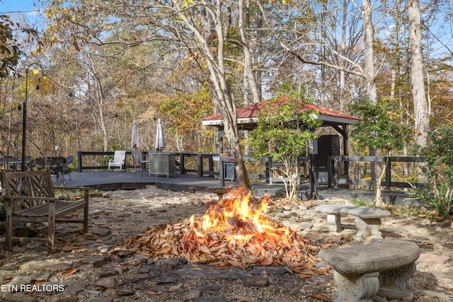 view of yard with a wooden deck, a gazebo, and a fire pit