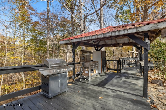 wooden deck featuring area for grilling and a gazebo