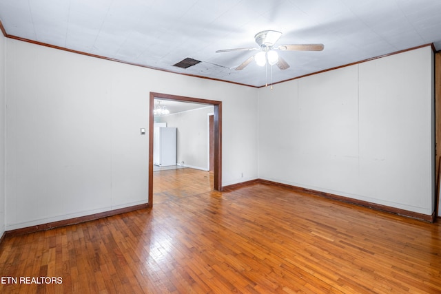 spare room featuring wood-type flooring, ceiling fan, and crown molding