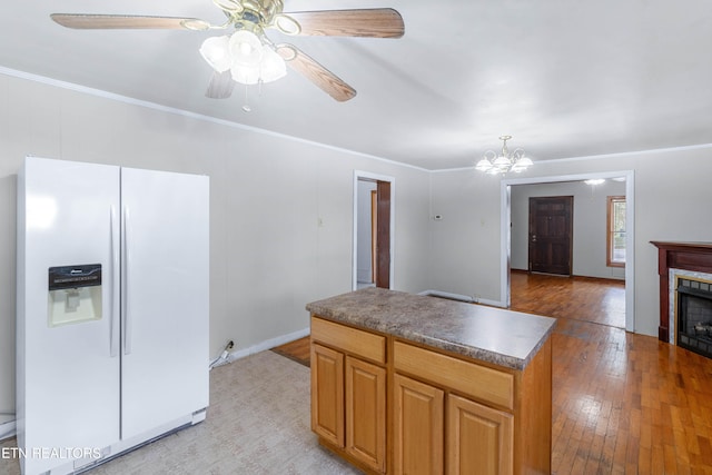 kitchen featuring ceiling fan with notable chandelier, white fridge with ice dispenser, light hardwood / wood-style flooring, crown molding, and a center island