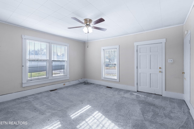 carpeted empty room featuring ornamental molding and ceiling fan