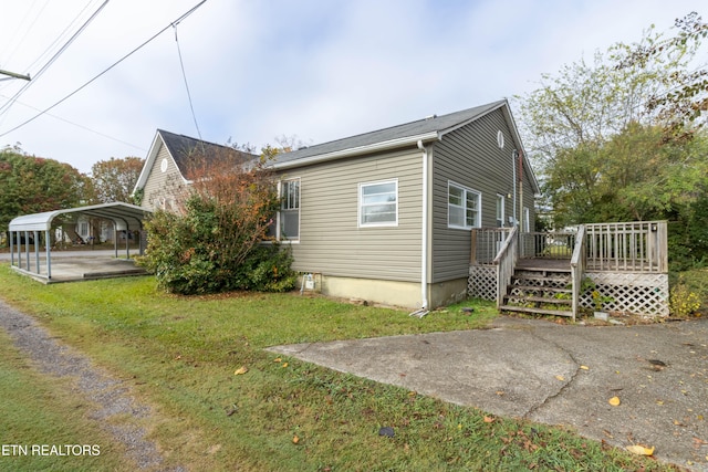 view of side of property with a carport, a yard, and a deck