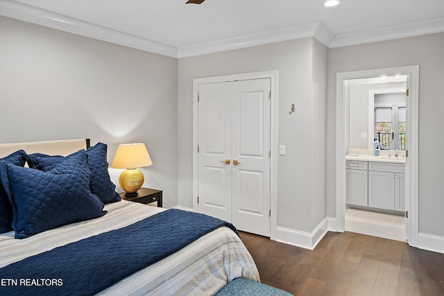 bedroom with dark hardwood / wood-style floors, ensuite bath, sink, and crown molding