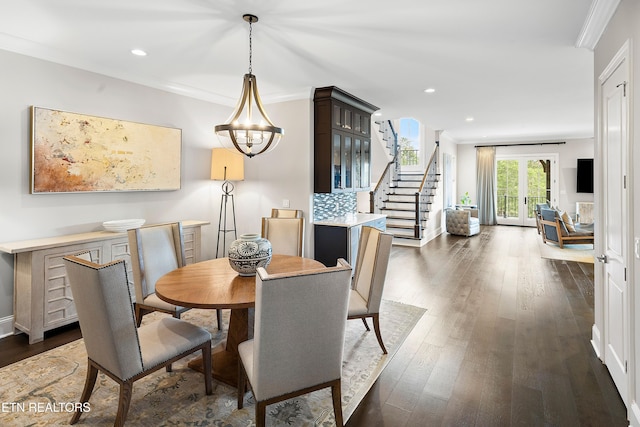 dining room featuring a chandelier, dark hardwood / wood-style floors, and crown molding