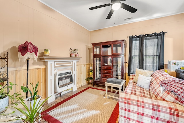 living room featuring wood walls, hardwood / wood-style flooring, ceiling fan, and heating unit