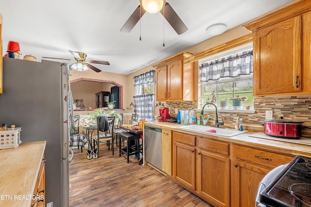 kitchen featuring backsplash, plenty of natural light, light hardwood / wood-style flooring, and appliances with stainless steel finishes