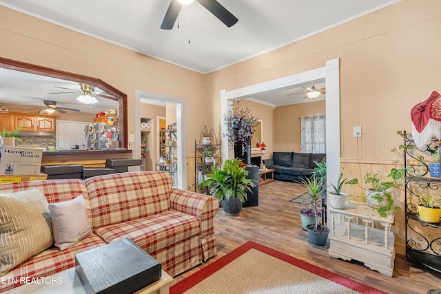 living room featuring crown molding and light hardwood / wood-style flooring