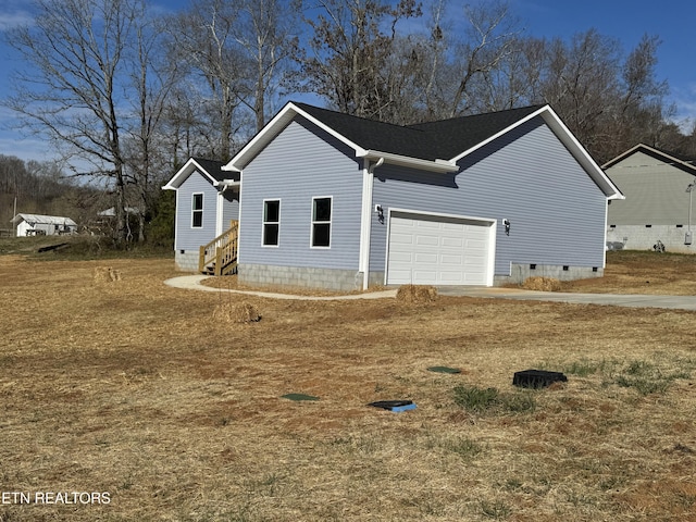 view of side of home with crawl space, an attached garage, and entry steps