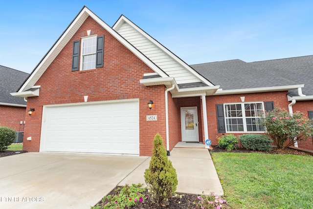 front of property with central air condition unit, a front yard, and a garage