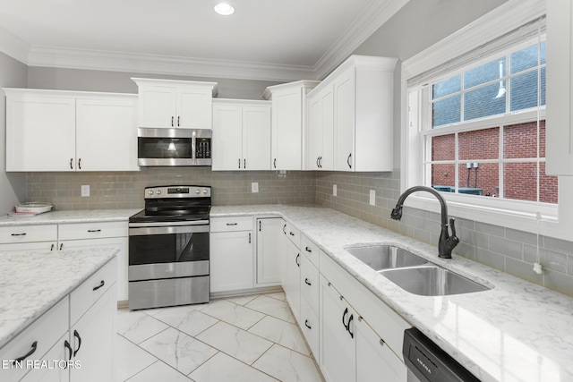 kitchen with marble finish floor, a sink, ornamental molding, and appliances with stainless steel finishes