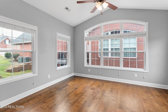 empty room with dark wood-style flooring, baseboards, ceiling fan, and visible vents