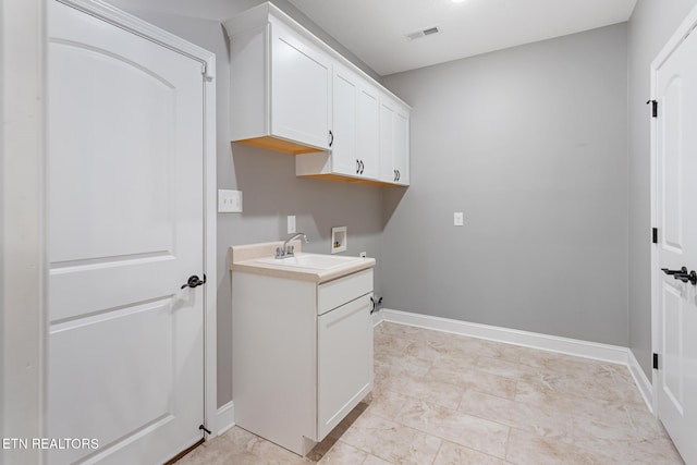 laundry area featuring baseboards, a sink, visible vents, cabinet space, and washer hookup