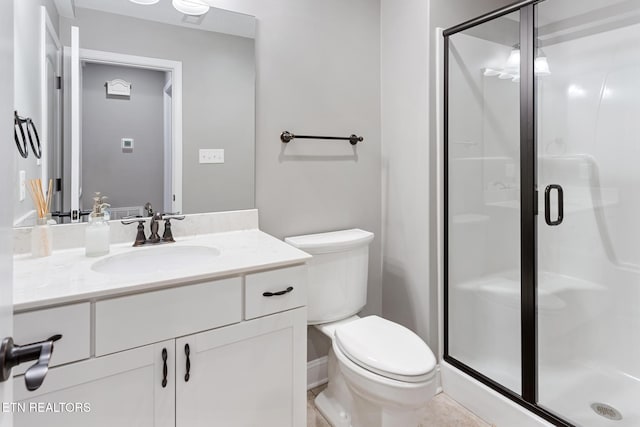 bathroom with a stall shower, toilet, and vanity