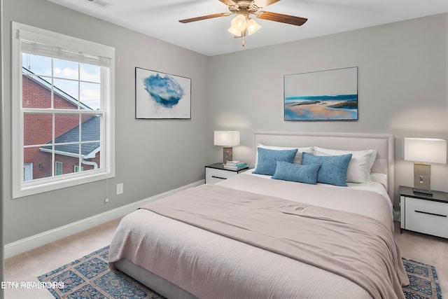 bedroom with light carpet, baseboards, visible vents, and a ceiling fan