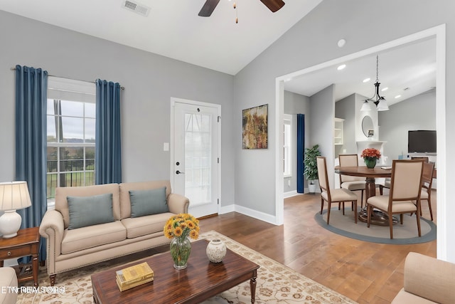 living room featuring high vaulted ceiling, baseboards, ceiling fan, visible vents, and wood finished floors