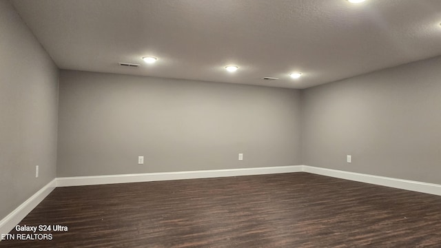 empty room featuring dark wood-style flooring and baseboards