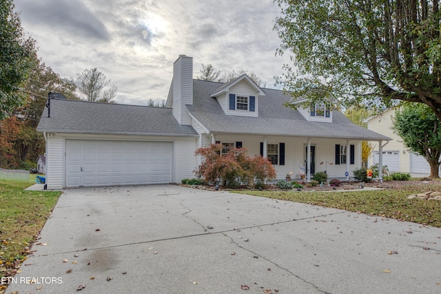 cape cod home with a garage and covered porch