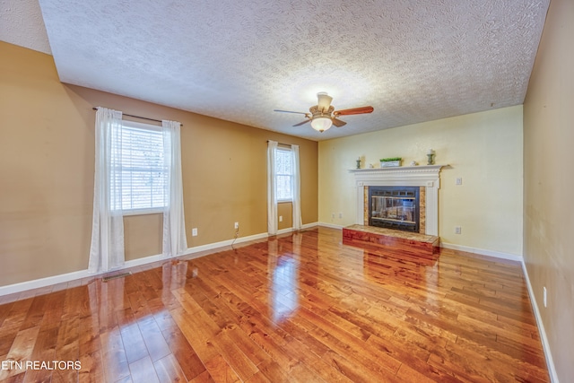 unfurnished living room featuring a textured ceiling, hardwood / wood-style flooring, and ceiling fan