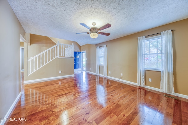 unfurnished living room featuring a textured ceiling, hardwood / wood-style flooring, and ceiling fan