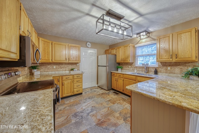 kitchen with appliances with stainless steel finishes, decorative light fixtures, decorative backsplash, sink, and kitchen peninsula