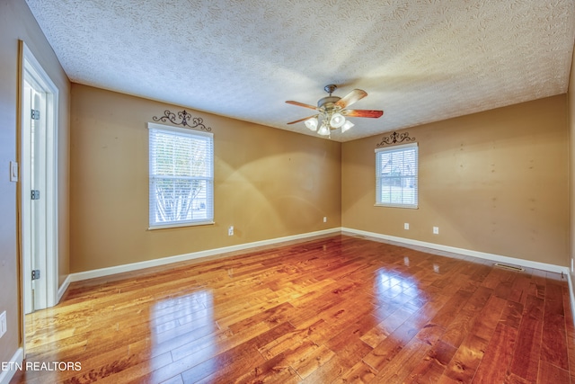 spare room featuring light hardwood / wood-style floors, ceiling fan, and a textured ceiling