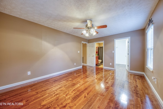 spare room with a textured ceiling, ceiling fan, and light hardwood / wood-style flooring