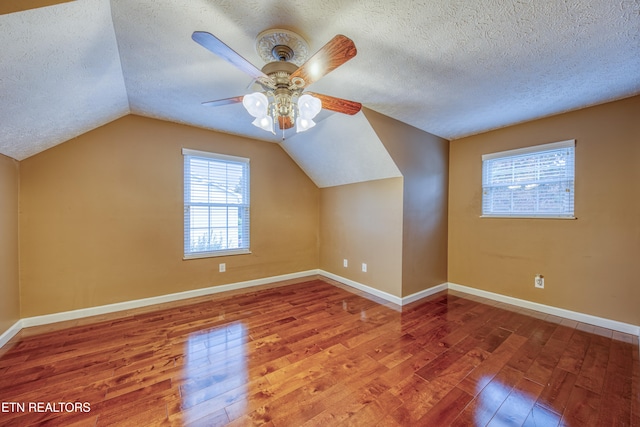 bonus room featuring lofted ceiling, a textured ceiling, hardwood / wood-style flooring, and ceiling fan