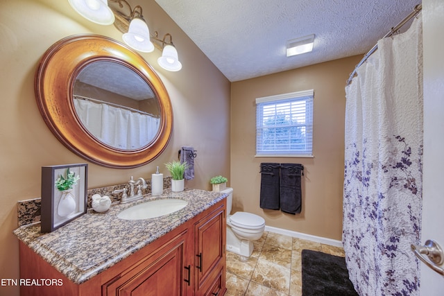 bathroom featuring vanity, a textured ceiling, and toilet