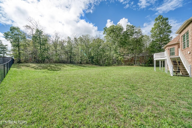 view of yard featuring stairway, fence, and a deck