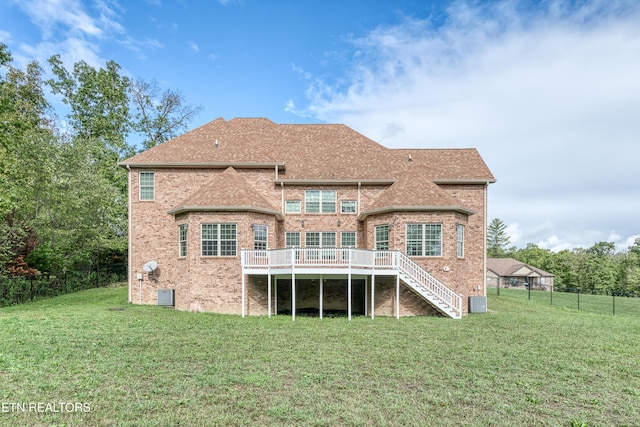 back of property with a lawn, stairway, brick siding, and a fenced backyard