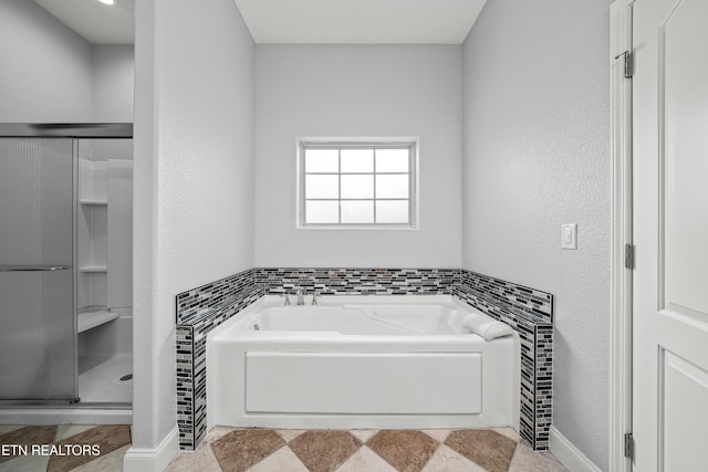 bathroom with a shower stall and a garden tub