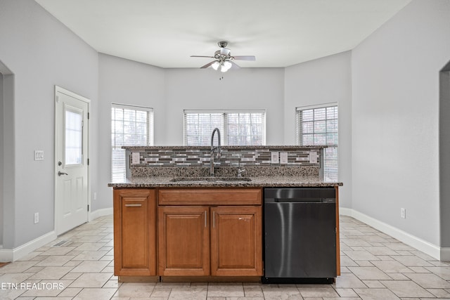 kitchen with stone counters, backsplash, a wealth of natural light, and sink