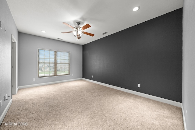 spare room with ceiling fan, carpet, baseboards, and visible vents