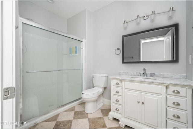 bathroom with vanity, toilet, baseboards, and a shower stall
