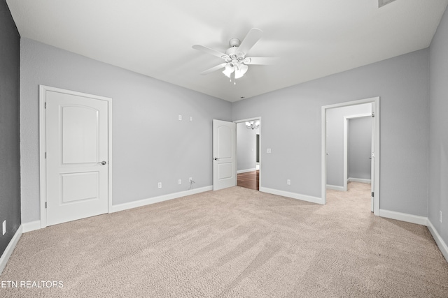 unfurnished bedroom with baseboards, light carpet, and a ceiling fan