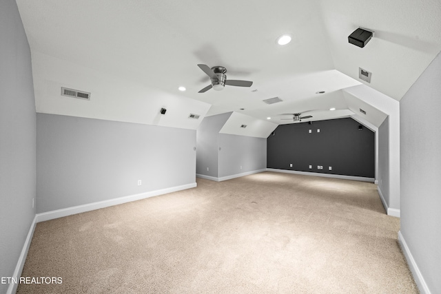 additional living space featuring vaulted ceiling, visible vents, ceiling fan, and light carpet