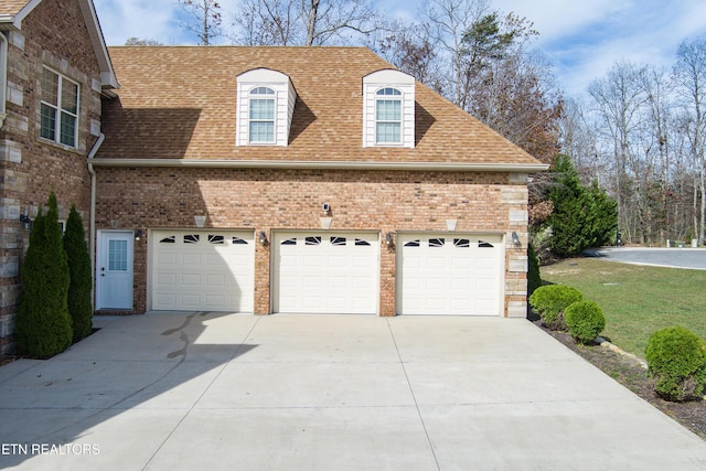view of side of home with concrete driveway, roof with shingles, and brick siding